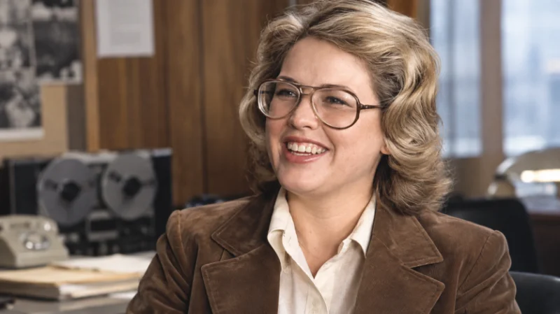 : Megan Marshack working at a newsroom desk with a typewriter and tape recorder